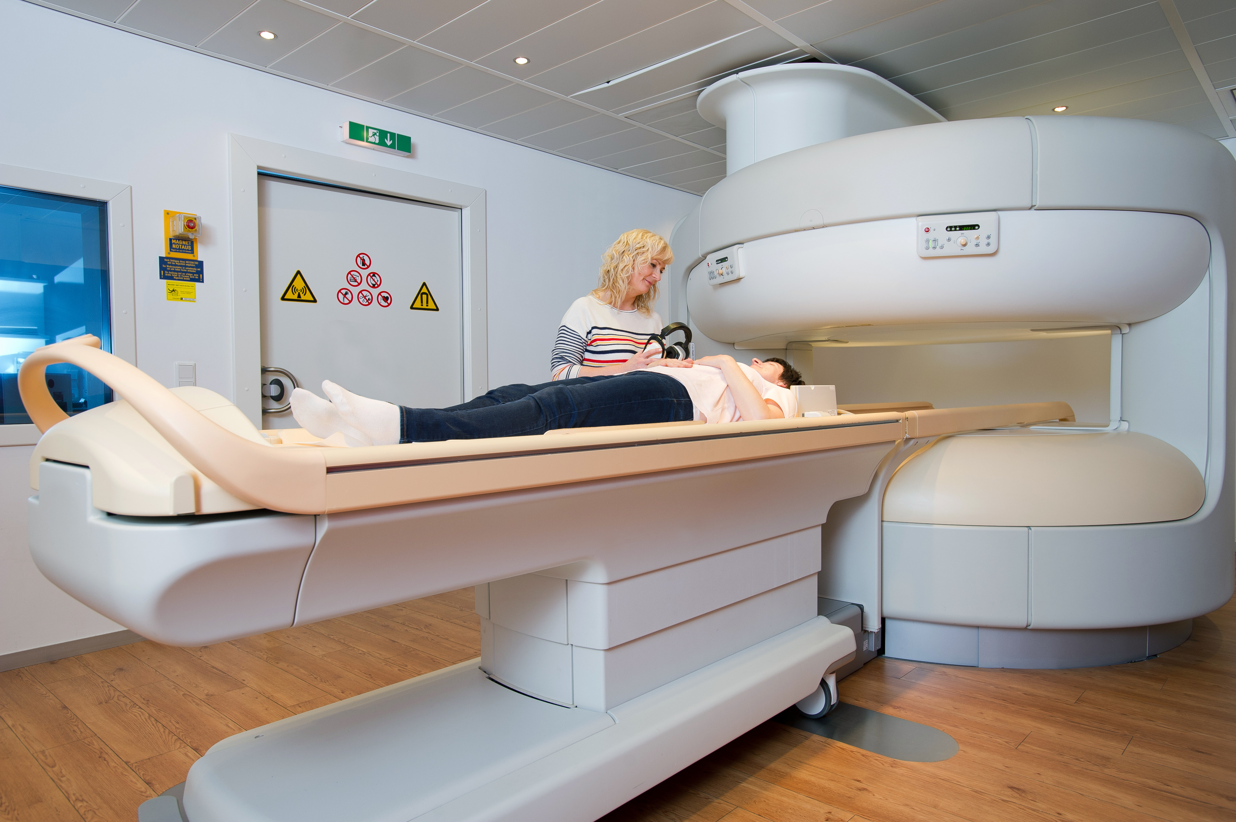 Modern MRI machine with technician assisting patient